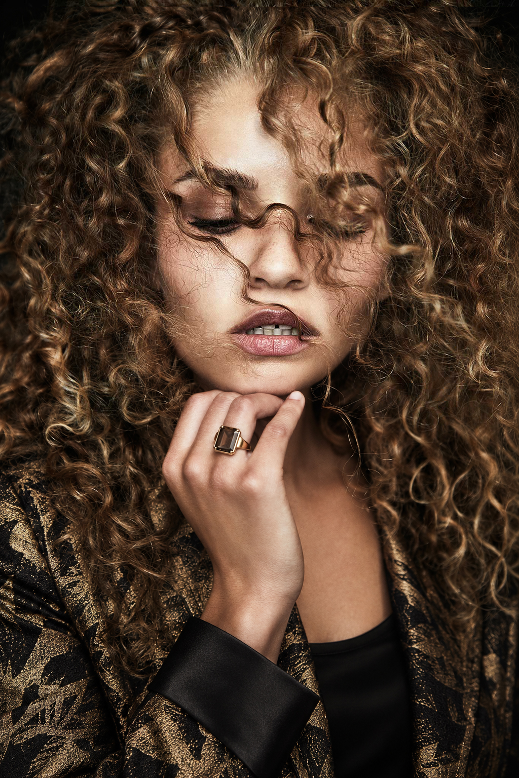 Close-up portrait with curls and a gold patterned jacket
