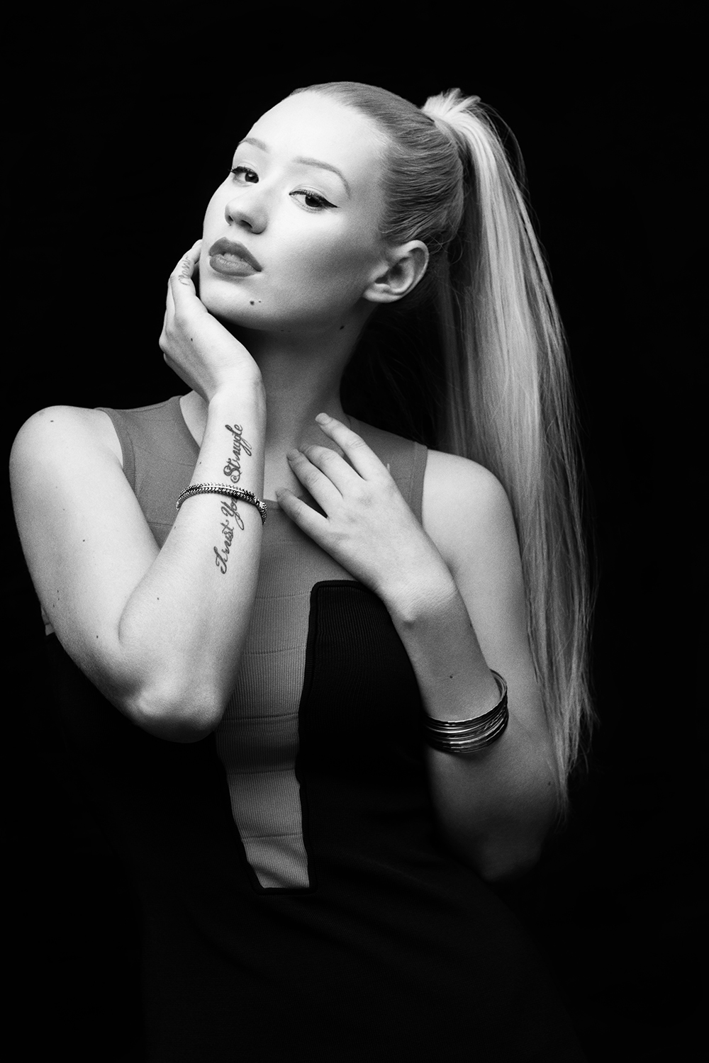 Black and white portrait with a high ponytail against black